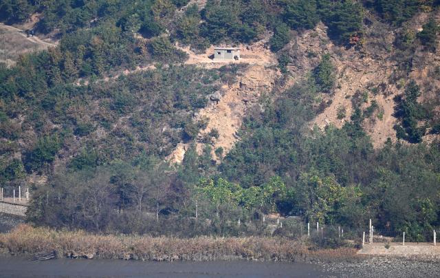 A what appears to be a North Korean self-propelled howitzer (R bottom) on the North side of the Demilitarised Zone (DMZ) dividing the two Koreas, is seen from a South Korean observation deck at Aegibong Peace Ecopark in Gimpo on October 27, 2026. (Photo by Jung Yeon-je / AFP)