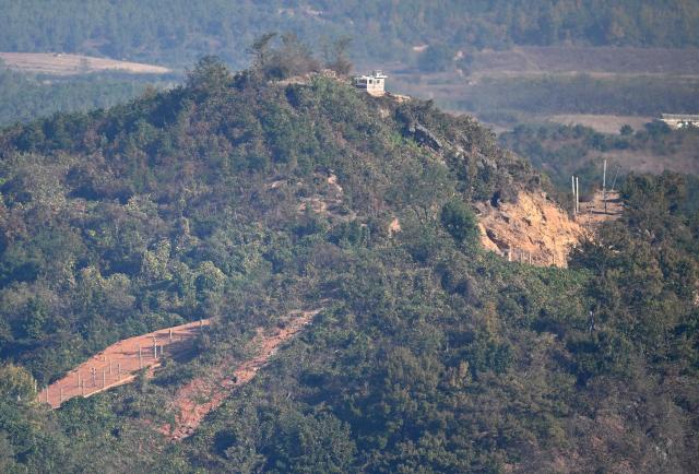 A North Korean guard post and military fences on the North side of the Demilitarised Zone (DMZ) dividing the two Koreas, are seen from a South Korean observation deck at Aegibong Peace Ecopark in Gimpo on October 27, 2026. (Photo by Jung Yeon-je / AFP)