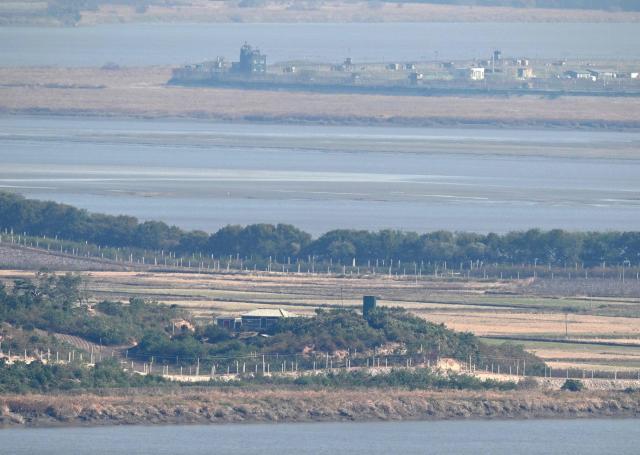A North Korean guard post and military fences (bottom) on the North side of the Demilitarised Zone (DMZ) dividing the two Koreas, and South Korean guard posts (top) are seen from a South Korean observation deck at Aegibong Peace Ecopark in Gimpo on October 27, 2026. (Photo by Jung Yeon-je / AFP)