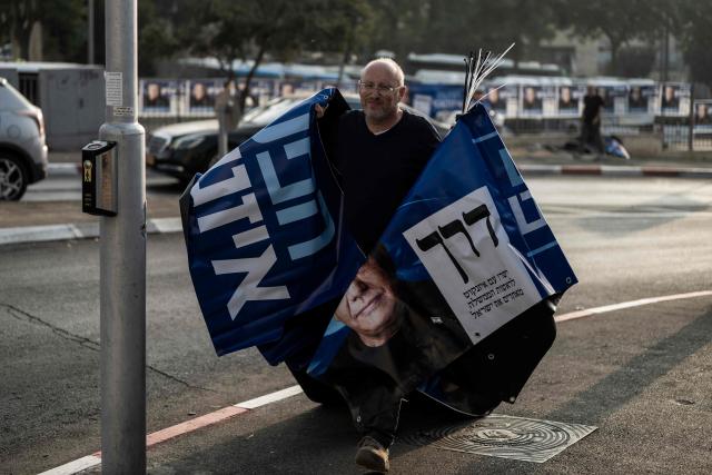 A supporter of the Yashar party, led by Gadi Eisenkot, arranges electoral banners outside a polling station in Jerusalem on October 27, 2026, on the day of Israel's legislative election. A deeply divided Israel heads to the polls on October 27 for the first time since Hamas's October 7, 2023 attack, with voters delivering their verdict on veteran Prime Minister Benjamin Netanyahu and the country's rightward drift. (Photo by Jewel SAMAD / AFP)