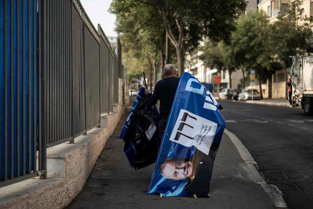 TOPSHOT - A supporter of the Yashar party, led by Gadi Eisenkot, arranges electoral banners outside a polling station in Jerusalem on October 27, 2026, on the day of Israel's legislative election. A deeply divided Israel heads to the polls on October 27 for the first time since Hamas's October 7, 2023 attack, with voters delivering their verdict on veteran Prime Minister Benjamin Netanyahu and the country's rightward drift. (Photo by Jewel SAMAD / AFP)