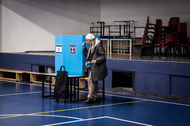 An elderly woman leaves the voting booth at a polling station in Jerusalem on October 27, 2026, on the day of Israel's legislative election. A deeply divided Israel heads to the polls on October 27 for the first time since Hamas's October 7, 2023 attack, with voters delivering their verdict on veteran Prime Minister Benjamin Netanyahu and the country's rightward drift. (Photo by John WESSELS / AFP)