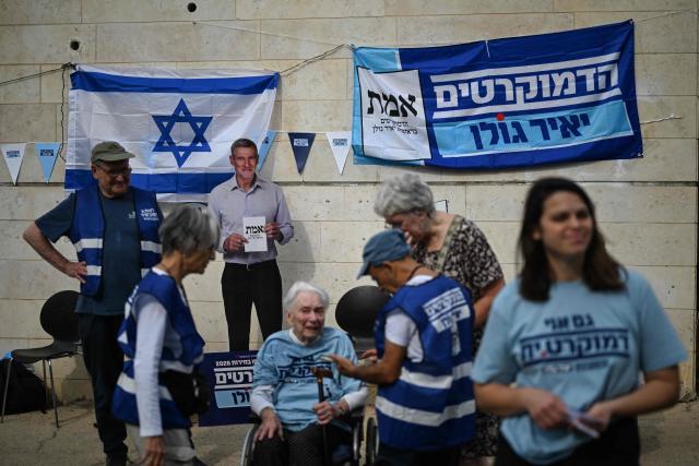 Campaigners gather outside a polling station in Jerusalem on October 27, 2026, on the day of Israel's legislative election. (Photo by Jewel SAMAD / AFP)