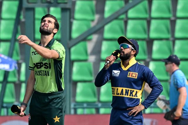 Pakistan's captain Shaheen Shah Afridi (L) tosses the coin next to Sri Lanka's captain Kusal Mendis before the start of the one-day international (ODI) tri-series cricket match between Pakistan and Sri Lanka at the Gaddafi Stadium in Lahore on October 27, 2026. (Photo by ARIF ALI / AFP)