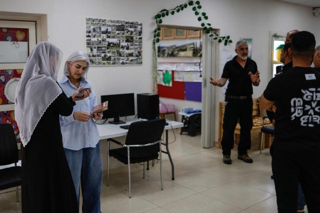 A member (2nd L) of the Druze community arrives at a polling station in the Druze village of Ein Qiniye, in the Israeli-annexed Golan Heights, on October 27, 2026, on the day of Israel's legislative election. (Photo by Jalaa MAREY / AFP)