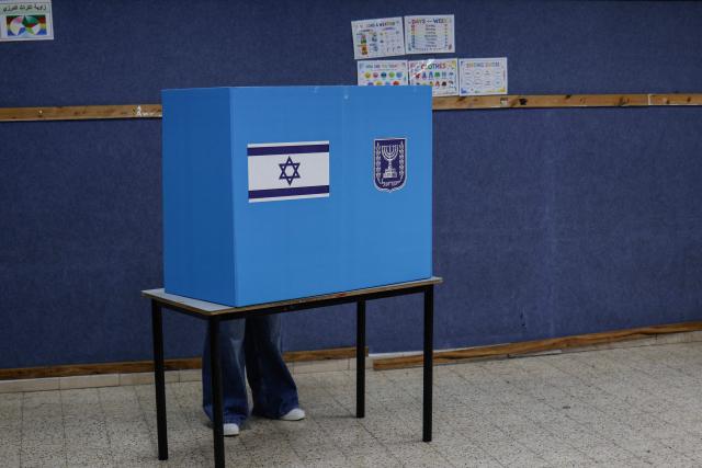 A member of the Druze community stands in a voting booth at a polling station in the Druze village of Ein Qiniye, in the Israeli-annexed Golan Heights, on October 27, 2026, on the day of Israel's legislative election. (Photo by Jalaa MAREY / AFP)
