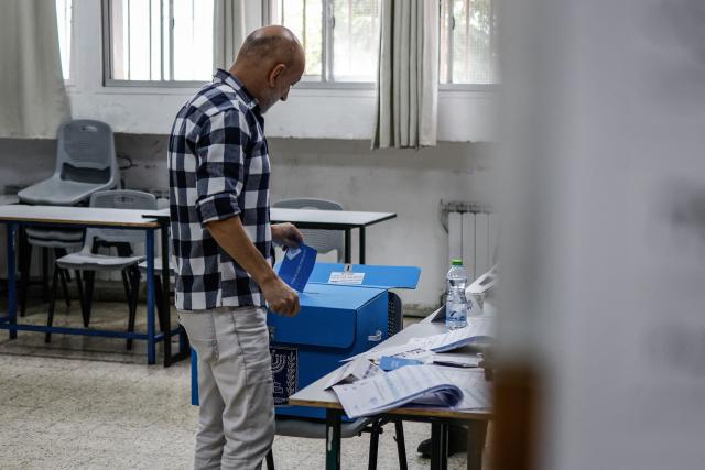A member of the Druze community casts his ballot at a polling station in the Druze village of Ein Qiniye, in the Israeli-annexed Golan Heights, on October 27, 2026, on the day of Israel's legislative election. (Photo by Jalaa MAREY / AFP)
