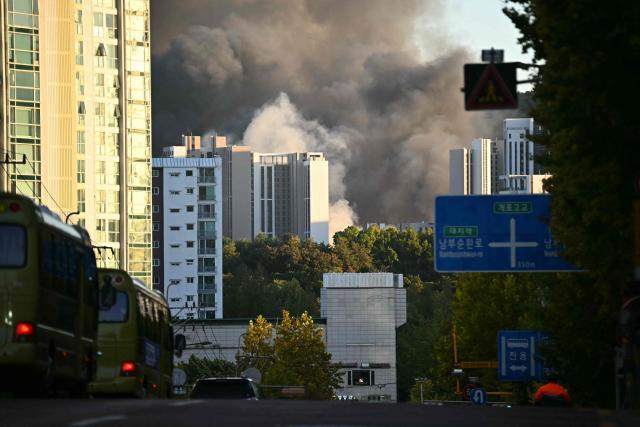 A general view of smoke billowing in the sky from a fire at Guryong Village in Seoul on October 27, 2026. (Photo by Philip FONG / AFP)