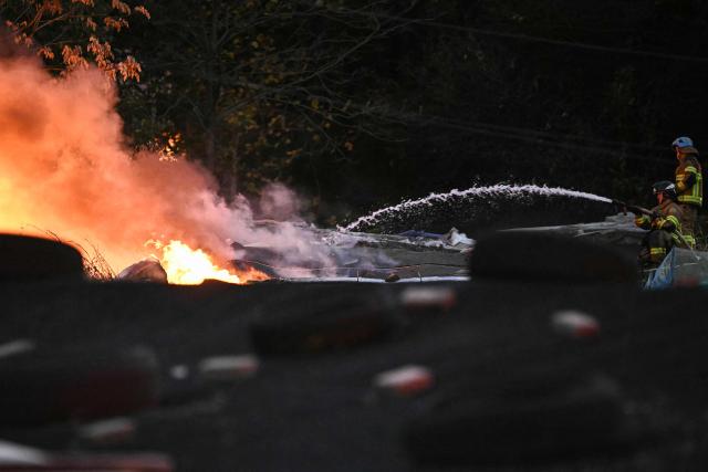 Firefighters extinguish a fire at Guryong Village in Seoul on October 27, 2026. (Photo by Philip FONG / AFP)