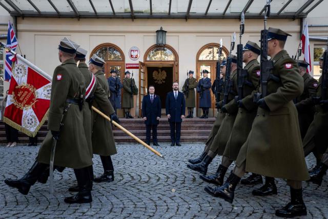 Poland's Deputy Prime Minister and Minister of National Defence Wladyslaw Kosiniak-Kamysz (C-R) and Britain's Secretary of State for Defence Wes Streeting (C-L) review a military honor guard as they take part in an official welcoming ceremony before their meeting in Warsaw, Poland, on October 27, 2026. (Photo by Wojtek RADWANSKI / AFP)