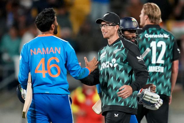 India's Naman Dhir (L) is congratulated by New Zealand's captain Mitchell Santner after their win during the third T20i cricket match between New Zealand and India at the Hnry Stadium in Wellington on October 27, 2026. (Photo by Marty MELVILLE / AFP)