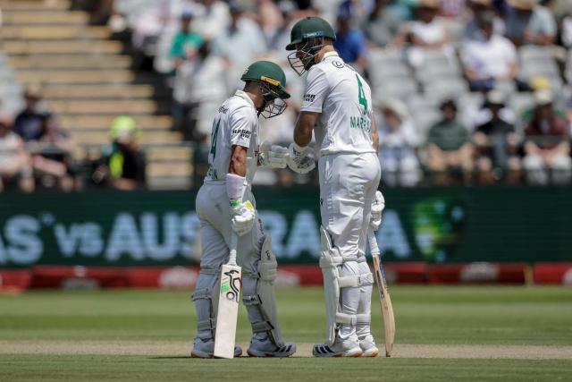 South Africa's Marques Ackerman (L) and South Africa's Aiden Markram (R) bump their fists on day one of the third Test match between South Africa and Australia at Newlands stadium in Cape Town on October 27, 2026. (Photo by Marco Longari / AFP)