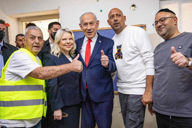 Israel's Prime Minister Benjamin Netanyahu (C) and his wife Sara (2nd L) react at a polling station in Jerusalem on October 27, 2026, on the day of Israel's legislative election. Netanyahu called on Israelis to vote "the right way" on October 27 as he cast his ballot in Jerusalem, facing a close-fought race in a pivotal general election. Israelis are flocking to the polls for the first time since Hamas's October 7, 2023 attack, with a deeply divided electorate delivering their verdict on the veteran leader. (Photo by Yonatan Sindel / POOL / AFP)