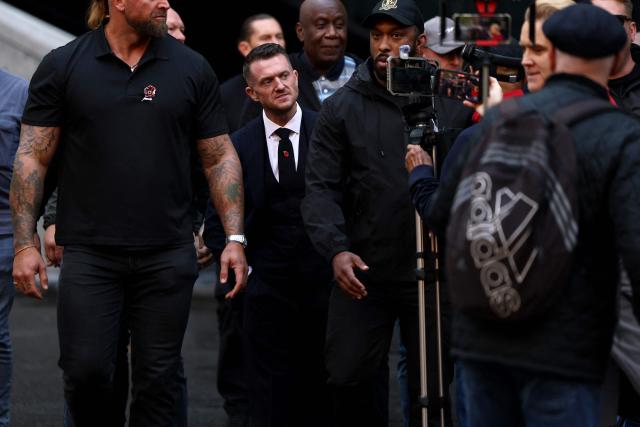 British far-right activist Tommy Robinson (C), real name Stephen Yaxley-Lennon, arrives at the Southwark Crown Court in London on October 27, 2026. Robinson, who is being tried under his real name, has denied charges of harassing two journalists through his X account between August 5 and 7, 2024. (Photo by Toby Shepheard / AFP)