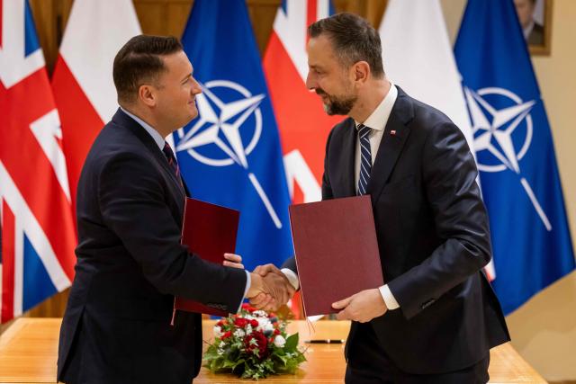 Poland's Deputy Prime Minister and Defence Minister Wladyslaw Kosiniak-Kamysz (C R) and Britain's Defence Secretary Wes Streeting (C L) shake hands after signing a defence agreement designed to deter Russian threats during a meeting at the Defence Ministry in Warsaw on October 27, 2026. (Photo by Wojtek RADWANSKI / AFP)