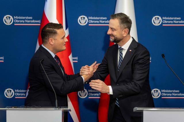 Poland's Deputy Prime Minister and Defence Minister Wladyslaw Kosiniak-Kamysz (R) and Britain's Defence Secretary Wes Streeting (L) shake hands after signing a defence agreement designed to deter Russian threats during a meeting at the Defence Ministry in Warsaw on October 27, 2026. (Photo by Wojtek RADWANSKI / AFP)