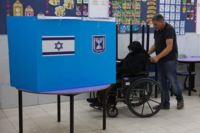 An elderly woman casts her ballot at a polling station in the southern bedouin city of Rahat on October 27, 2026 during Israel's legislative election. A deeply divided Israel headed to the polls for the first time since Hamas's October 7, 2023 attack, with voters delivering their verdict on veteran prime minister and the country's rightward drift. (Photo by HAZEM BADER / AFP)