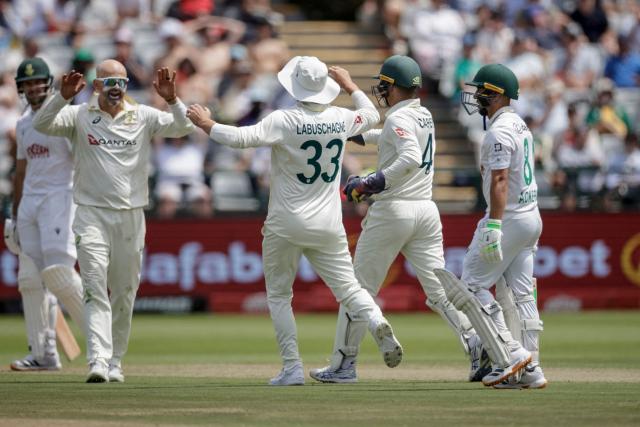 Australia's Nathan Lyon (2nd L) celebrates with his teammates after dismissing South Africa's Marques Ackerman (R) on day one of the third Test match between South Africa and Australia at Newlands stadium in Cape Town on October 27, 2026. (Photo by Marco Longari / AFP)