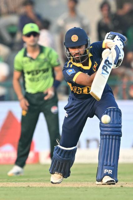 Sri Lanka's Pavan Rathnayake (R) plays a shot during the one-day international (ODI) tri-series cricket match between Pakistan and Sri Lanka at the Gaddafi Stadium in Lahore on October 27, 2026. (Photo by ARIF ALI / AFP)