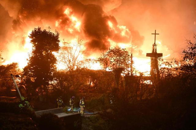 Firefighters work at the scene of a fire in the shanty village of Guryong on the outskirts of Gangnam district in Seoul on October 27, 2026. (Photo by Jung Yeon-je / AFP)