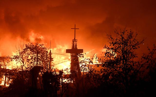 A church's cross tower is seen at the scene of a fire in the shanty village of Guryong on the outskirts of Gangnam district in Seoul on October 27, 2026. (Photo by Jung Yeon-je / AFP)