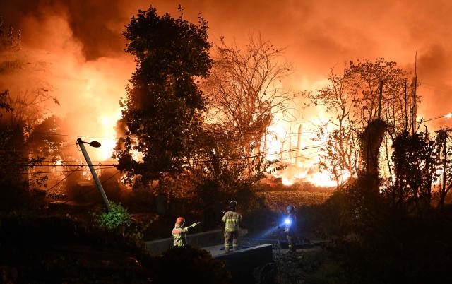 Firefighters work at the scene of a fire in the shanty village of Guryong on the outskirts of Gangnam district in Seoul on October 27, 2026. (Photo by Jung Yeon-je / AFP)