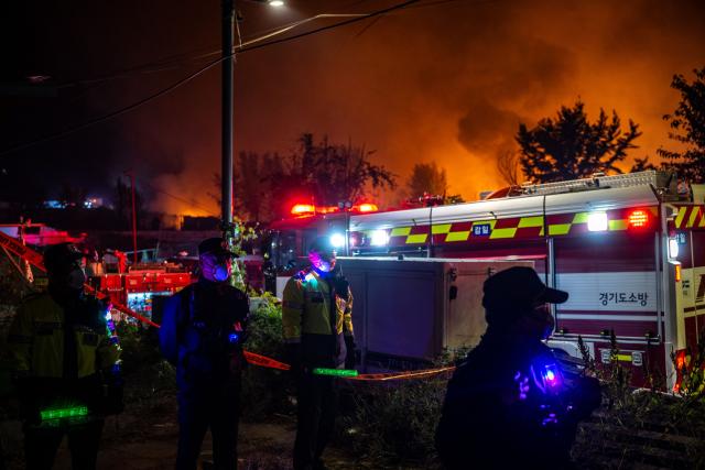 Firefighters and police officers work at the scene of a fire in the shanty village of Guryong on the outskirts of Gangnam district in Seoul on October 27, 2026. (Photo by Philip FONG / AFP)