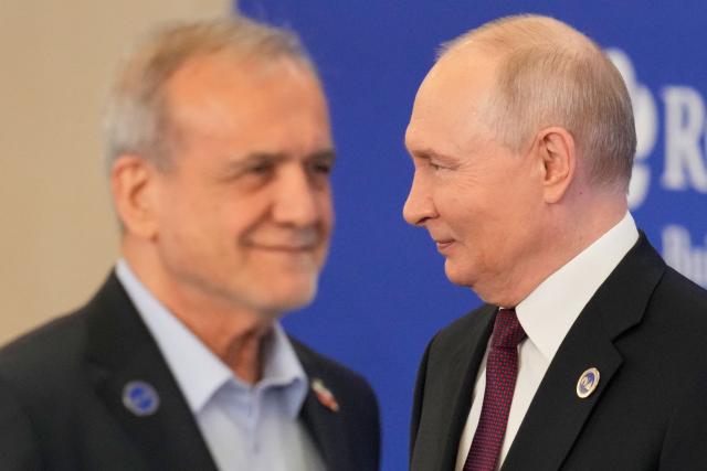 TOPSHOT - Russian President Vladimir Putin welcomes Iranian President Masoud Pezeshkian during the 8th Gas Exporting Countries Forum (GECF) summit at the World Trade Center in Moscow on October 27, 2026. (Photo by Pavel Bednyakov / POOL / AFP)