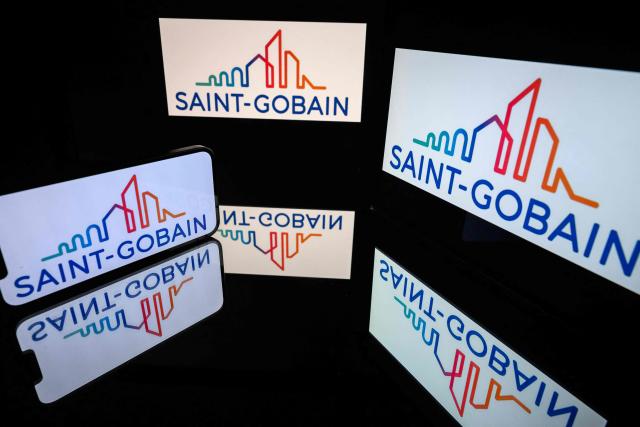 (FILES) This photograph shows screens displaying the logo of the company Saint-Gobain, listed on the CAC 40, the main stock market index of the Paris Stock Exchange, in Toulouse on March 31, 2026. Saint-Gobain announced on October 27, 2026 a 1.8% year-on-year increase in its revenue for the third quarter of 2026 and confirmed its goal of achieving an EBITDA margin, a profitability indicator, of more than 15% in 2026. (Photo by Lionel BONAVENTURE / AFP)