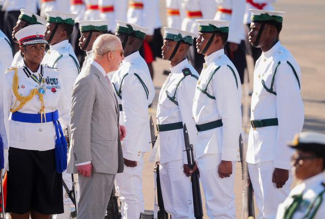 Britain's King Charles III inspects the guard of honour, made up of members of the Royal Bahamas Police Force and the Royal Bahamas Defence Force, as he arrives at Lynden Pindling International Airport, in Nassau, at the start of the royal visit to The Bahamas on October 27, 2026. King Charles III is arriving to begin a weeks long tour of The Bahamas, Guyana and Antigua & Barbuda. (Photo by Aaron Chown / POOL / AFP)
