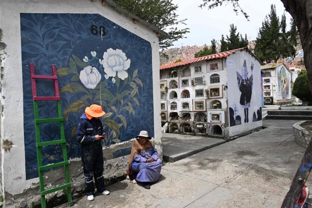 A worker stands beside a mural at the General Cemetery in La Paz on October 27, 2026, ahead of All Saints' Day celebrations. (Photo by Aizar RALDES / AFP)