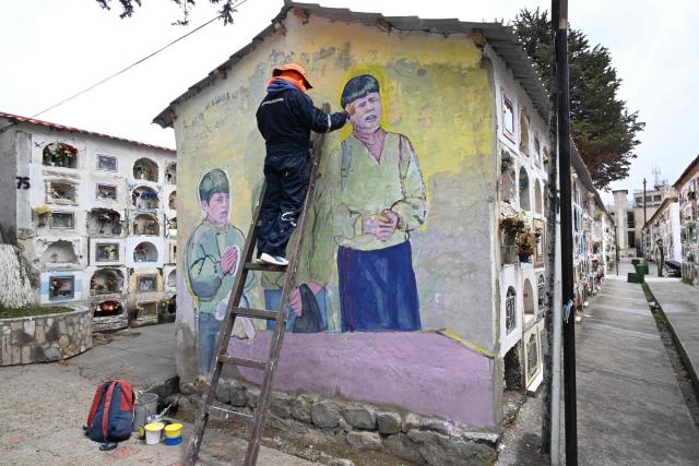 A worker paints a mural at the General Cemetery in La Paz on October 27, 2026, ahead of All Saints' Day celebrations. (Photo by Aizar RALDES / AFP)