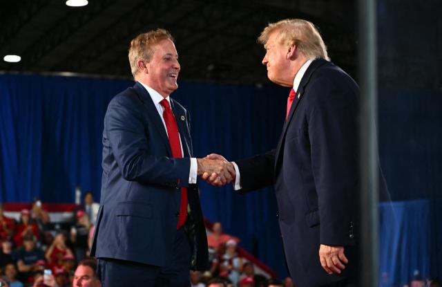 US President Donald Trump shakes hands with Texas Attorney General and Republican Senate candidate Ken Paxton (L) during a midterm campaign rally at the Port of Corpus Christi in Corpus Christi, Texas, on October 27, 2026. (Photo by Kent NISHIMURA / AFP)