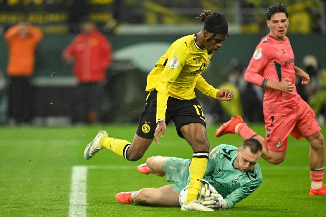Dortmund's Austrian midfielder #17 Carney Chukwuemeka (L) fails to score past Bremen's Estonia goalkeeper #01 Karl Hein during the German Cup (DFB-Pokal) football match between BVB Borussia Dortmund and Werder Bremen in Dortmund, western Germany on October 27, 2026. (Photo by INA FASSBENDER / AFP) / DFB REGULATIONS PROHIBIT ANY USE OF PHOTOGRAPHS AS IMAGE SEQUENCES AND QUASI-VIDEO.