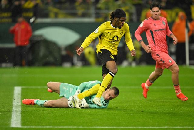 Dortmund's Austrian midfielder #17 Carney Chukwuemeka (C) fails to score past Bremen's Estonia goalkeeper #01 Karl Hein during the German Cup (DFB-Pokal) football match between BVB Borussia Dortmund and Werder Bremen in Dortmund, western Germany on October 27, 2026. (Photo by INA FASSBENDER / AFP) / DFB REGULATIONS PROHIBIT ANY USE OF PHOTOGRAPHS AS IMAGE SEQUENCES AND QUASI-VIDEO.