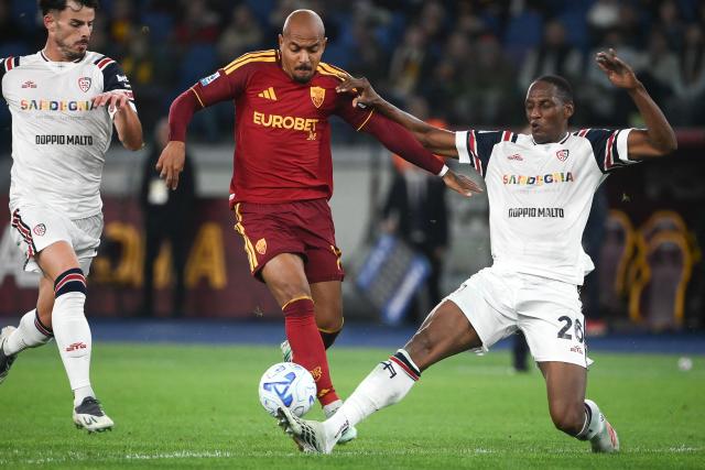 AS Roma's Dutch forward #14 Donyell Malen (C) and Cagliari's Colombian defender #26 Yerry Mina (R) fight for the ball during the Italian Serie A football match between AS Roma and Cagliari at the Olympic Stadium in Rome on October 27, 2026. (Photo by Isabella BONOTTO / AFP)
