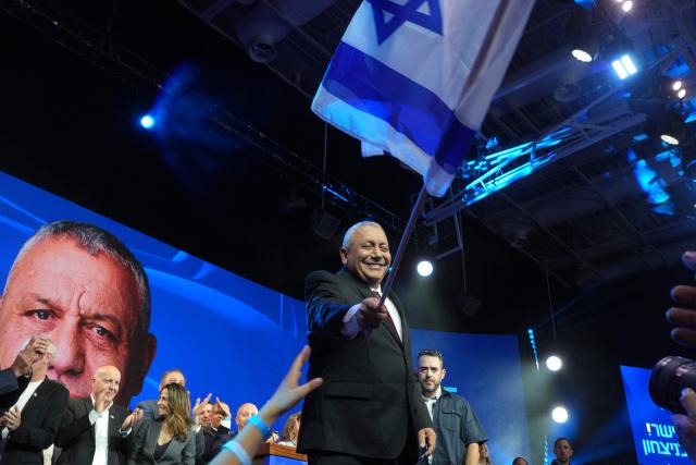 Yashar party leader Gadi Eisenkot waves Israel's national flag at the election night rally after the first exit polls were announced, in Tel Aviv on early October 28, 2026, during Israel's legislative elections. Opposition candidate Eisenkot said early on October 28 said Israel had chosen change after Prime Minister Benjamin Netanyahu and that he would seek to form a new government. (Photo by MAYA LEVIN / AFP)