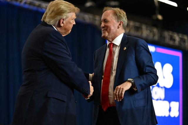 US President Donald Trump shakes hands with Texas Attorney General and Republican candidate for the US Senate Ken Paxton at a midterm campaign rally at Lubbock Memorial Civic Center in Lubbock, Texas on October 27, 2026. (Photo by Kent NISHIMURA / AFP)