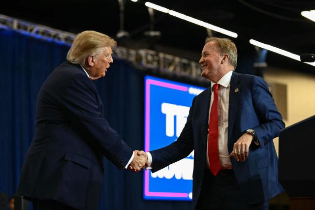 US President Donald Trump shakes hands with Texas Attorney General and Republican candidate for the US Senate Ken Paxton at a midterm campaign rally at Lubbock Memorial Civic Center in Lubbock, Texas on October 27, 2026. (Photo by Kent NISHIMURA / AFP)