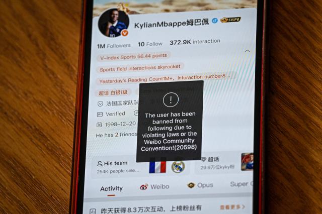 This photo illustration shows French football star Kylian Mbappe's Chinese social media Weibo account displaying the message: "The user has been banned from following due to violating laws of the Weibo Community Convention”, in Shanghai on October 28, 2026. Kylian Mbappe apologised on October 27, after the Real Madrid star was dropped by major Chinese brands for apparently joking about Mao Zedong in a video that has gone viral. (Photo by Jade GAO / AFP)