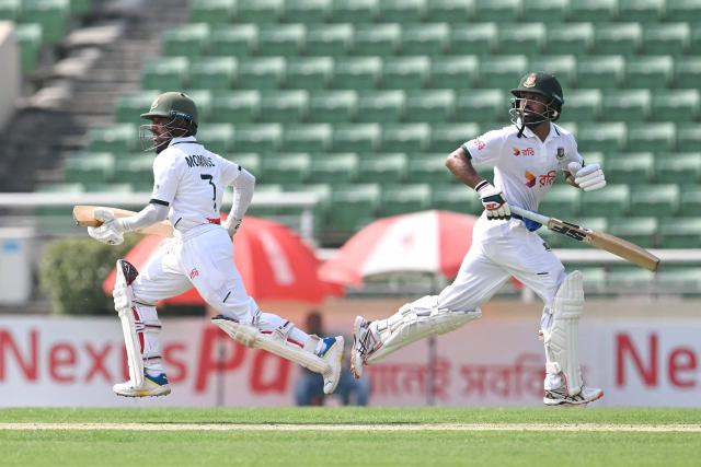Bangladesh's Shadman Islam (R) and Mominul Haque (L) run between the wickets during the first day of the first test cricket match between Bangladesh and West Indies at the Sher-e-Bangla National Stadium in Mirpur on October 28, 2026. (Photo by Salahuddin Ahmed / AFP)