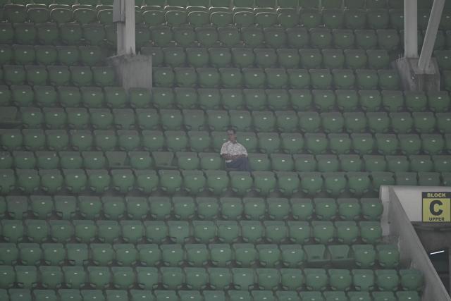 A spectator sits amid empty seats during the first day of the first test cricket match between Bangladesh and West Indies at the Sher-e-Bangla National Stadium in Mirpur on October 28, 2026. (Photo by Salahuddin Ahmed / AFP)