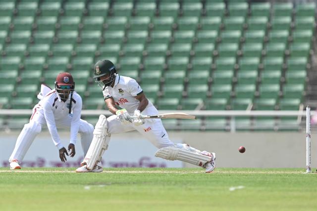 Bangladesh's captain Najmul Hossain Shanto (R) plays a shot as West Indies' wicketkeeper Amir Jangoo watches during the first day of the first test cricket match between Bangladesh and West Indies at the Sher-e-Bangla National Stadium in Mirpur on October 28, 2026. (Photo by Salahuddin Ahmed / AFP)