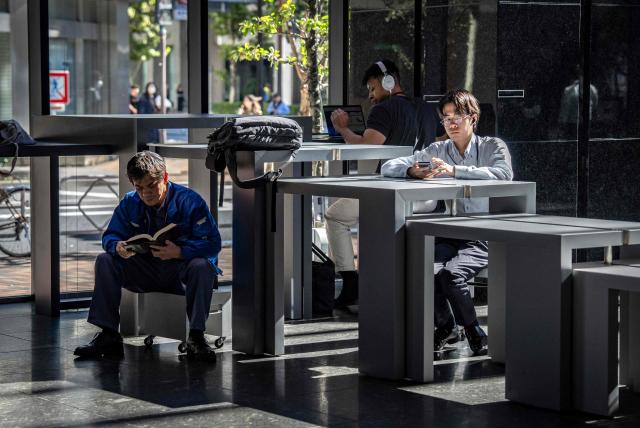 People sit at a rest area in Tokyo on October 28, 2026. (Photo by Yuichi YAMAZAKI / AFP)