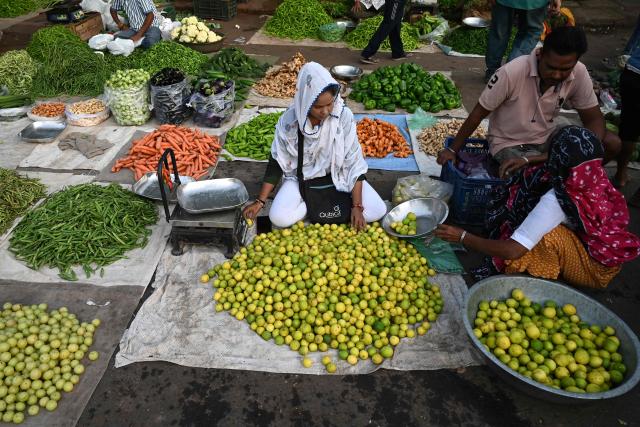 A vendor waits for customers at the Jamalpur vegetable market in Ahmedabad on October 28, 2026. (Photo by Shammi MEHRA / AFP)