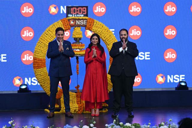 Indian billionaire and Reliance Industries chairman Mukesh Ambani's children and Jio Platforms board members (L-R) Akash Ambani, Isha Ambani and Anant Ambani greet the audience during Jio's initial public offering (IPO) listing ceremony at the National Stock Exchange (NSE) in Mumbai on October 28, 2026. Shares in India's Jio Platforms surged more than 21 percent on its market debut on October 28, after raising more than $3 billion in the country's biggest initial public offering. (Photo by Indranil MUKHERJEE / AFP)