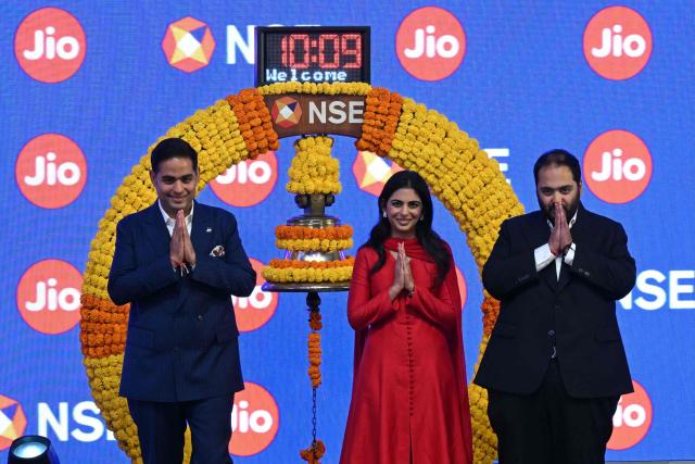 Indian billionaire and Reliance Industries chairman Mukesh Ambani's children and Jio Platforms board members (L-R) Akash Ambani, Isha Ambani and Anant Ambani greet the audience during Jio's initial public offering (IPO) listing ceremony at the National Stock Exchange (NSE) in Mumbai on October 28, 2026. Shares in India's Jio Platforms surged more than 21 percent on its market debut on October 28, after raising more than $3 billion in the country's biggest initial public offering. (Photo by Indranil MUKHERJEE / AFP)
