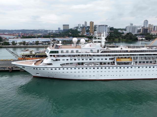 An aerial view shows the Villa Vie Residences' cruise ship Odyssey docked at Sihanoukville port in Preah Sihanouk province on October 28, 2026. Around 200 passengers who paid to live on a cruise ship while travelling the world were abruptly left in a Cambodian port after the company ran out of money, an official said on October 28. (Photo by Suy Se / AFP)