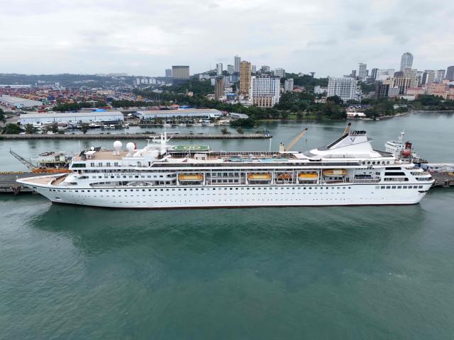 An aerial view shows the Villa Vie Residences' cruise ship Odyssey docked at Sihanoukville port in Preah Sihanouk province on October 28, 2026. Around 200 passengers who paid to live on a cruise ship while travelling the world were abruptly left in a Cambodian port after the company ran out of money, an official said on October 28. (Photo by Suy Se / AFP)