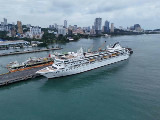 An aerial view shows the Villa Vie Residences' cruise ship Odyssey docked at Sihanoukville port in Preah Sihanouk province on October 28, 2026. Around 200 passengers who paid to live on a cruise ship while travelling the world were abruptly left in a Cambodian port after the company ran out of money, an official said on October 28. (Photo by Suy Se / AFP)